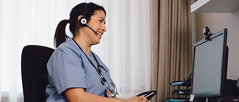 a nurse with a headset on taking patients help calls
