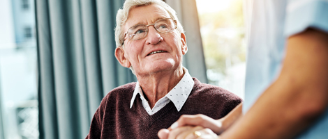 elderly man looking up at a care taker
